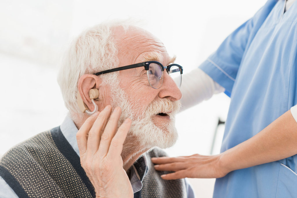 elderly man getting a hearing aid